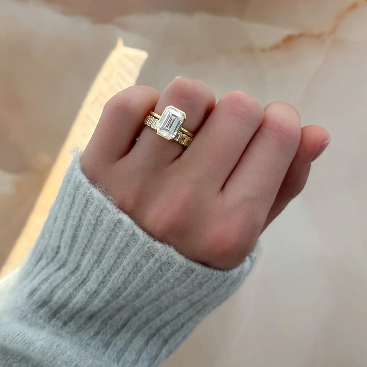 Emerald cut bezel engagement ring stacked perfectly with diamond eternity wedding band, showing flush fit bridal set on hand