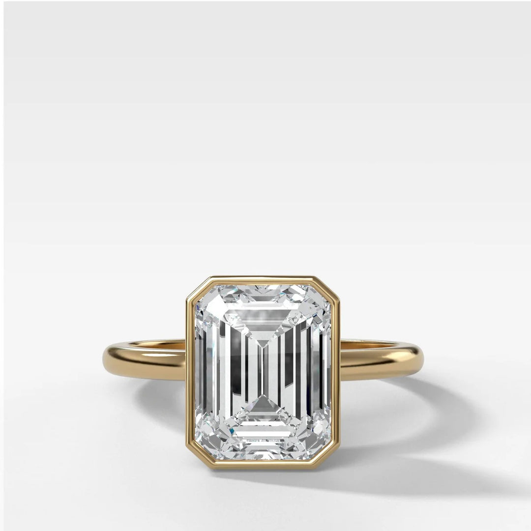 2.50ct emerald cut lab-grown diamond bezel set engagement ring in 14k yellow gold, top down view showing secure snag-free setting