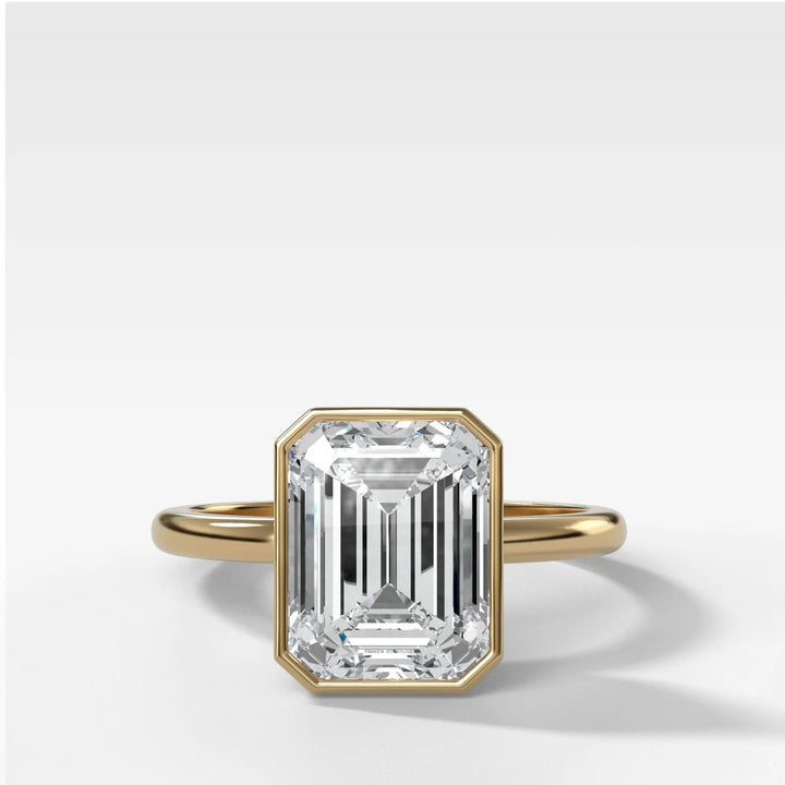 2.50ct emerald cut lab-grown diamond bezel set engagement ring in 14k yellow gold, top down view showing secure snag-free setting